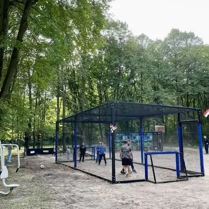 Football Box z bramkami zamontowany w parku leśnym - mieszkańcy grają w otoczeniu przyrody.